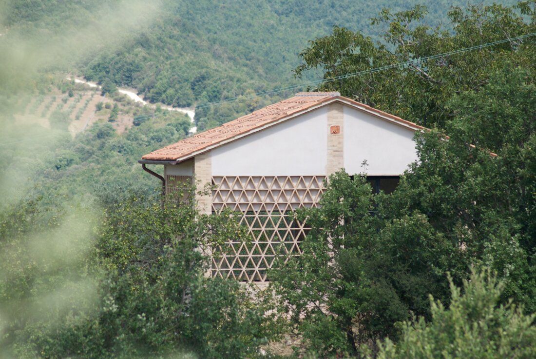 Building with a tiled roof and a wooden lattice among the trees