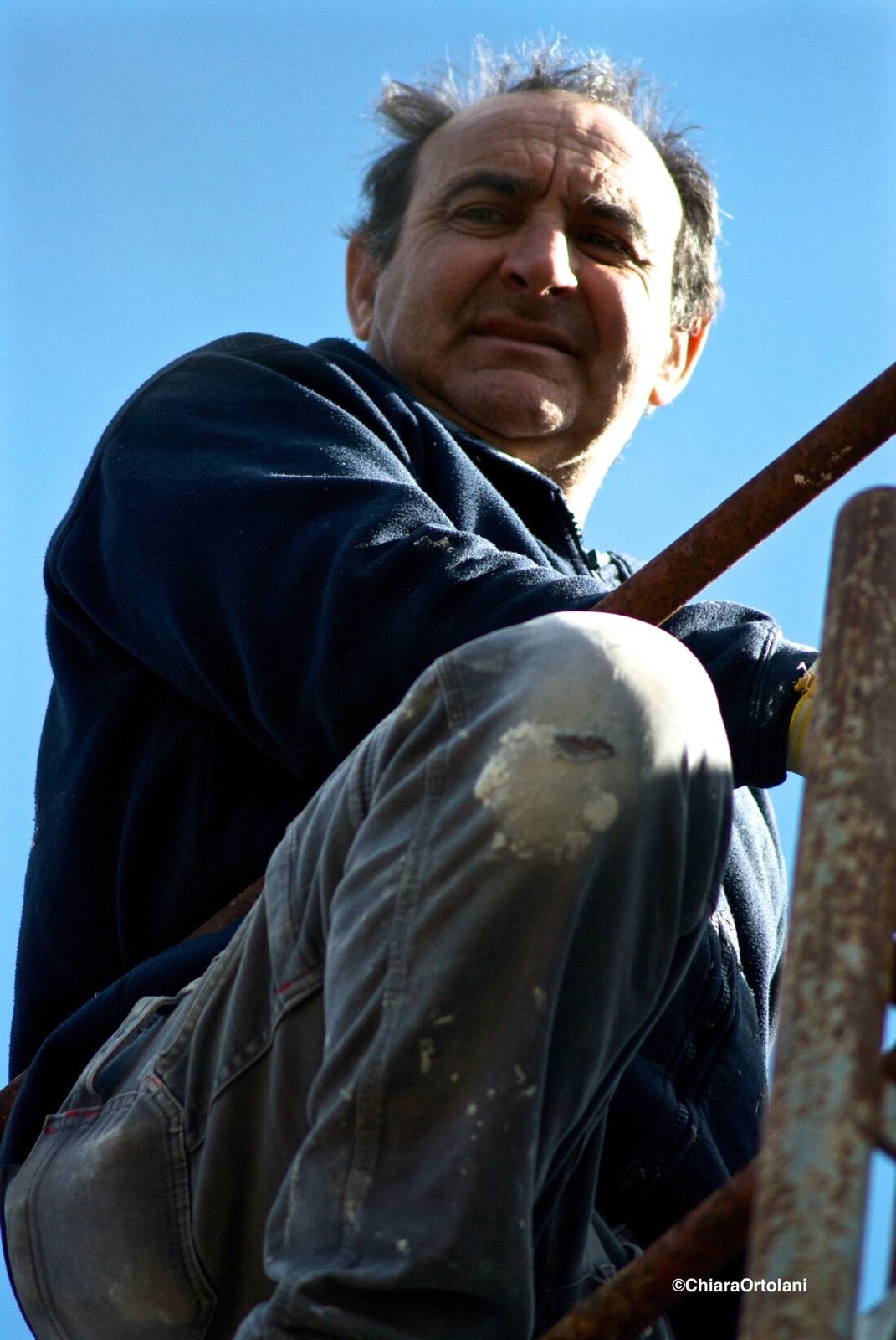 Operaio sorridente seduto su un ponteggio