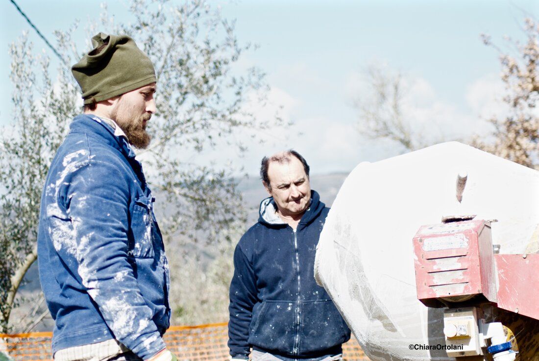 Operai accanto alla betoniera in cantiere